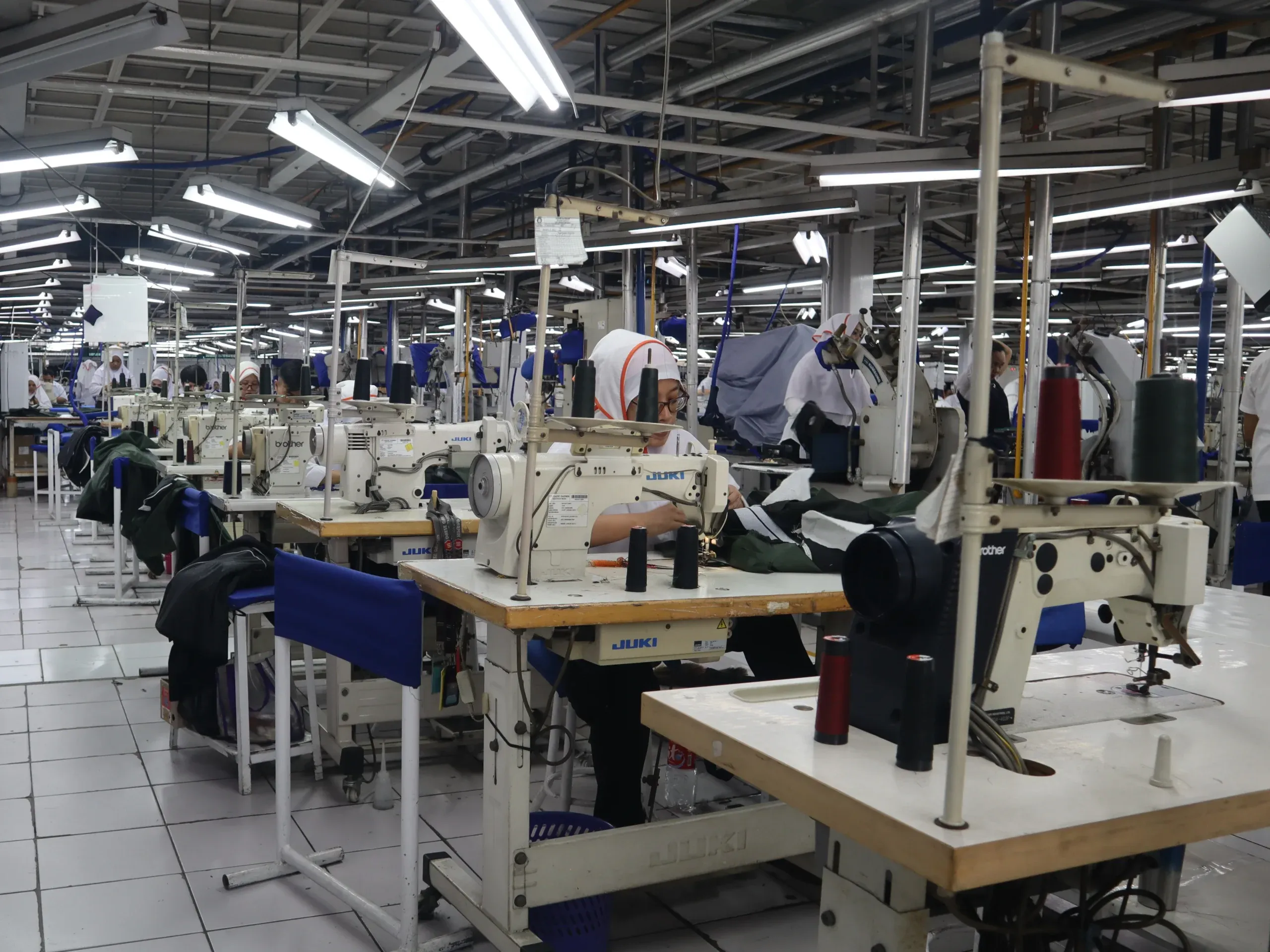 Lantai produksi Keno Konveksi dengan penjahit sedang bekerja menggunakan mesin jahit industri